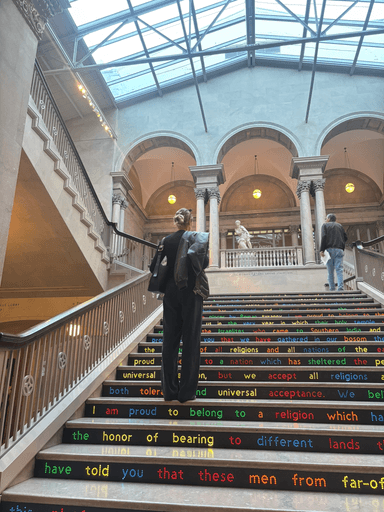 Keren on a grand staircase with words painted on every step